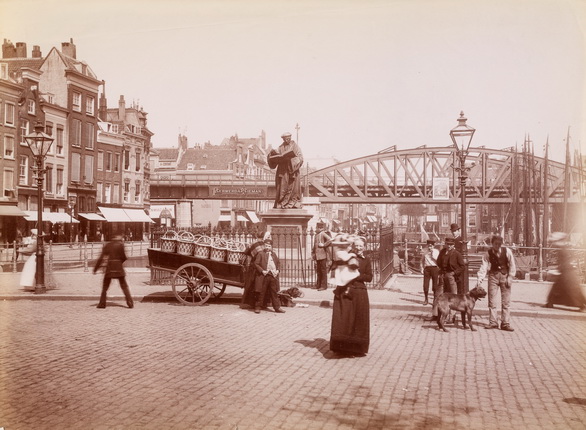 Неизвестный фотограф.
Роттердам. Статуя Эразма Роттердамского на Рыночной площади; на заднем плане — железнодорожный виадук над железной дорогой Роттердам — Дордрехт. 
1900-е.
Альбуминовый отпечаток
